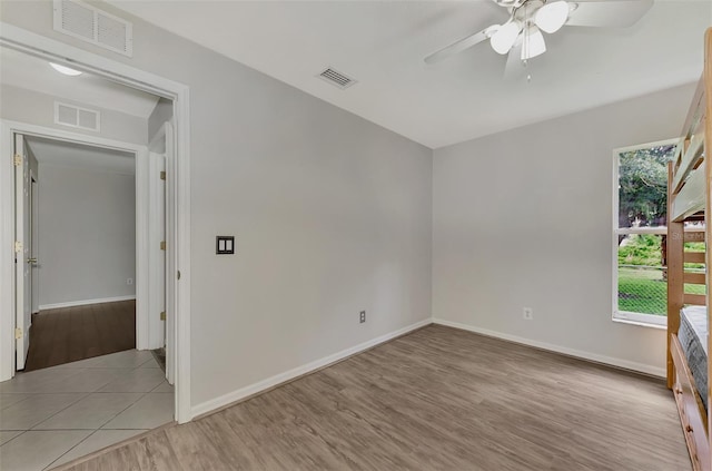 empty room with ceiling fan and light hardwood / wood-style flooring