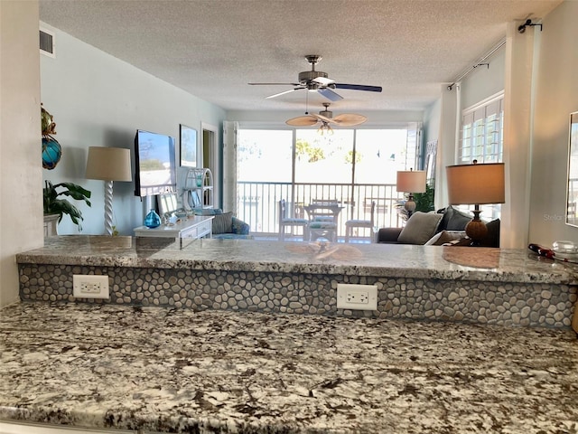 kitchen with ceiling fan and a textured ceiling