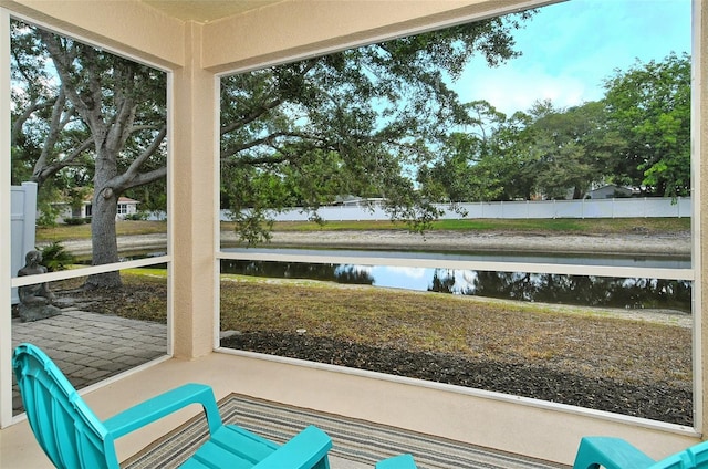 unfurnished sunroom featuring a water view