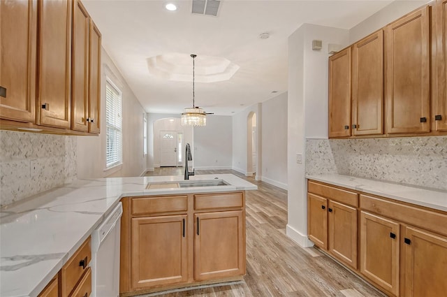 kitchen featuring white dishwasher, sink, a raised ceiling, and kitchen peninsula