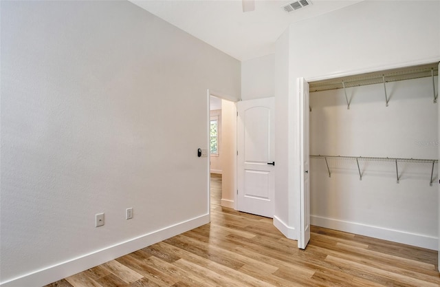 unfurnished bedroom featuring light hardwood / wood-style flooring, ceiling fan, and a closet