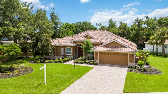 mediterranean / spanish home with a garage and a front lawn