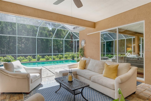 view of patio featuring ceiling fan, an outdoor hangout area, and glass enclosure