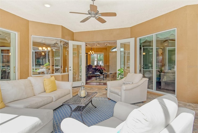 sunroom / solarium with ceiling fan with notable chandelier