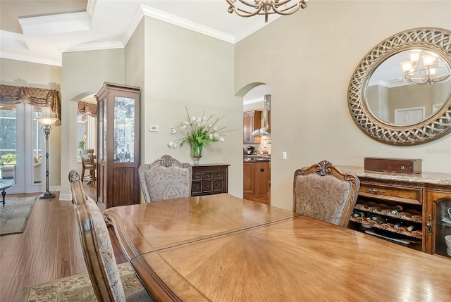 dining space with an inviting chandelier, hardwood / wood-style floors, and ornamental molding