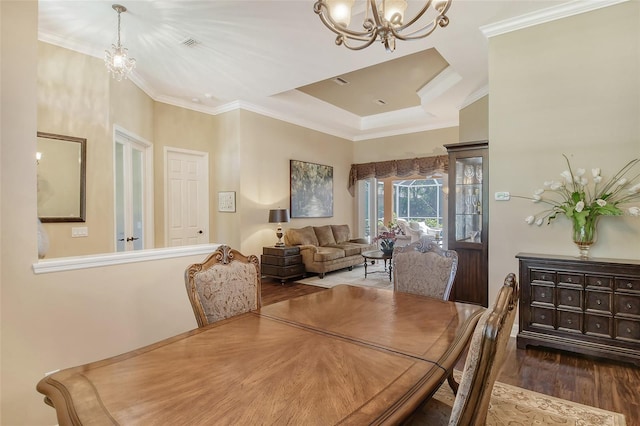 dining room with crown molding, a chandelier, and hardwood / wood-style floors