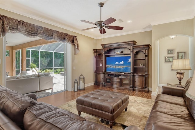 living room with ornamental molding, light hardwood / wood-style floors, and ceiling fan