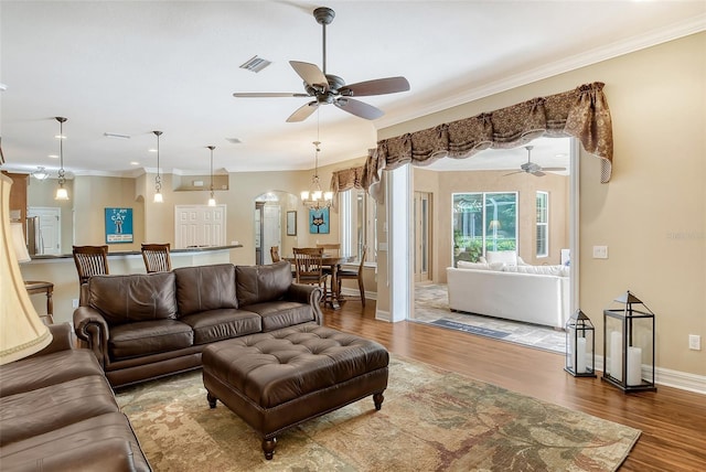 living room with ceiling fan, ornamental molding, and hardwood / wood-style floors