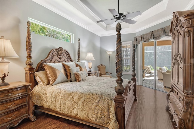 bedroom with dark wood-type flooring, crown molding, access to outside, a tray ceiling, and ceiling fan