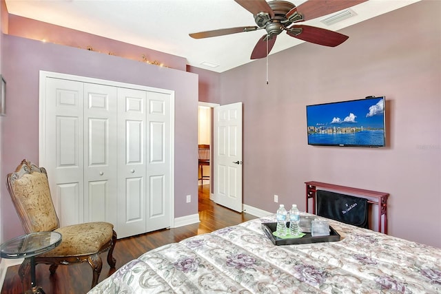 bedroom with dark hardwood / wood-style floors, ceiling fan, and a closet