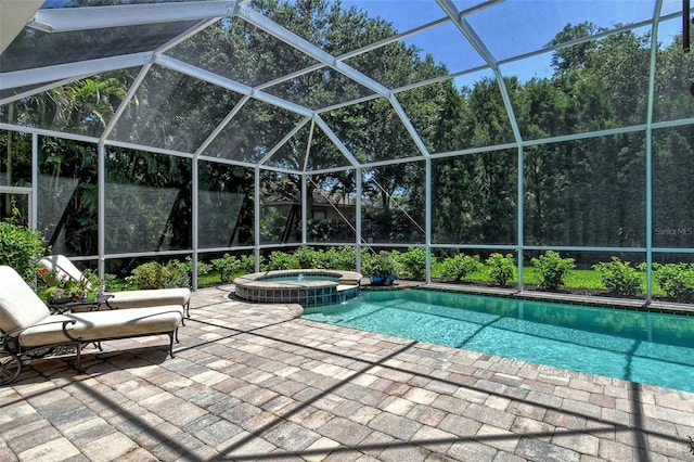 view of swimming pool with a lanai, a patio area, and an in ground hot tub