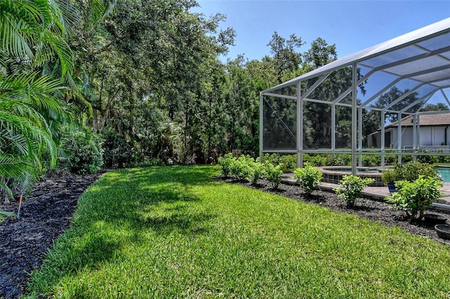 view of yard featuring an in ground hot tub and glass enclosure