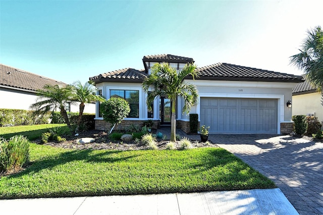 mediterranean / spanish house featuring a garage and a front yard