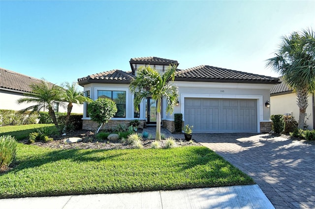 mediterranean / spanish-style home with a garage and a front lawn