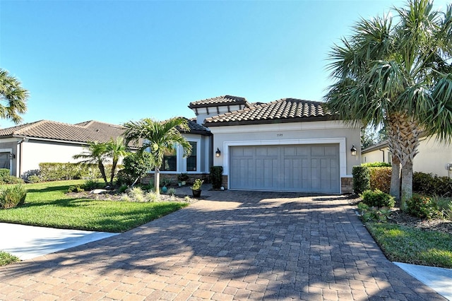 mediterranean / spanish home with a garage and a front lawn