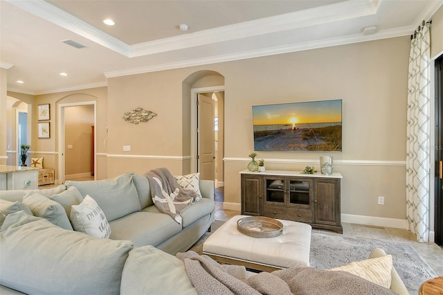 tiled living room featuring a tray ceiling and ornamental molding