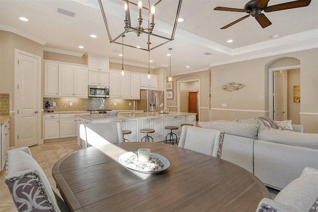 dining space with ornamental molding, sink, light tile patterned floors, and ceiling fan