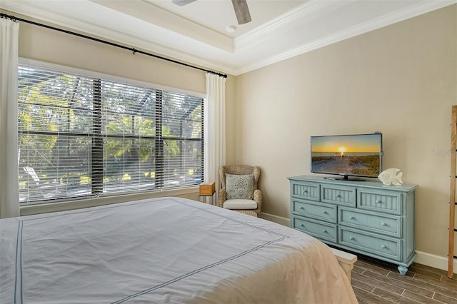 bedroom featuring a tray ceiling, crown molding, and ceiling fan