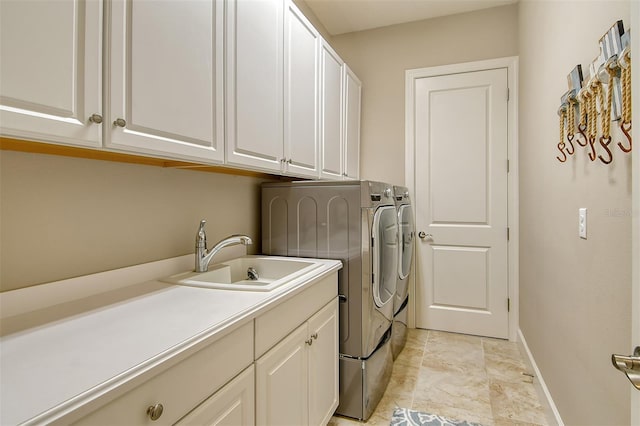 laundry room featuring sink, washing machine and dryer, and cabinets