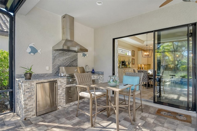 view of patio with area for grilling, ceiling fan, and an outdoor kitchen