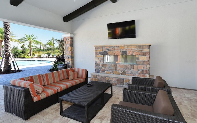 view of patio / terrace with ceiling fan and an outdoor living space with a fireplace