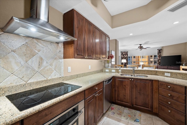 kitchen featuring appliances with stainless steel finishes, light stone countertops, sink, and wall chimney range hood