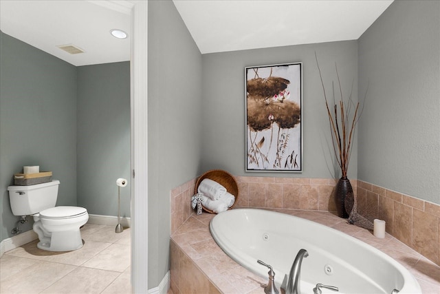 bathroom featuring tile patterned floors, toilet, and tiled tub