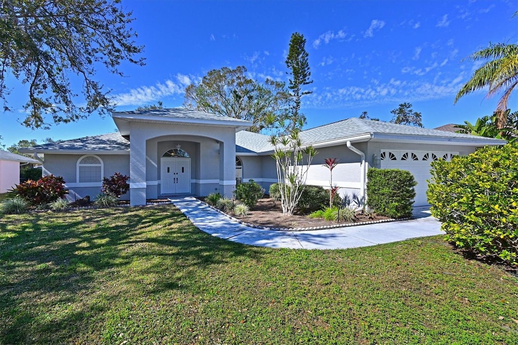 single story home featuring a garage and a front yard