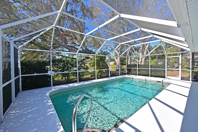 view of pool with glass enclosure and a patio area