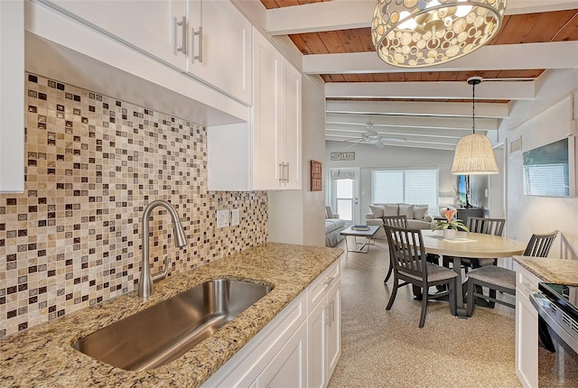 kitchen featuring decorative light fixtures, white cabinetry, sink, and decorative backsplash