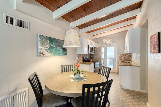 dining room with sink, light colored carpet, lofted ceiling with beams, and wooden ceiling