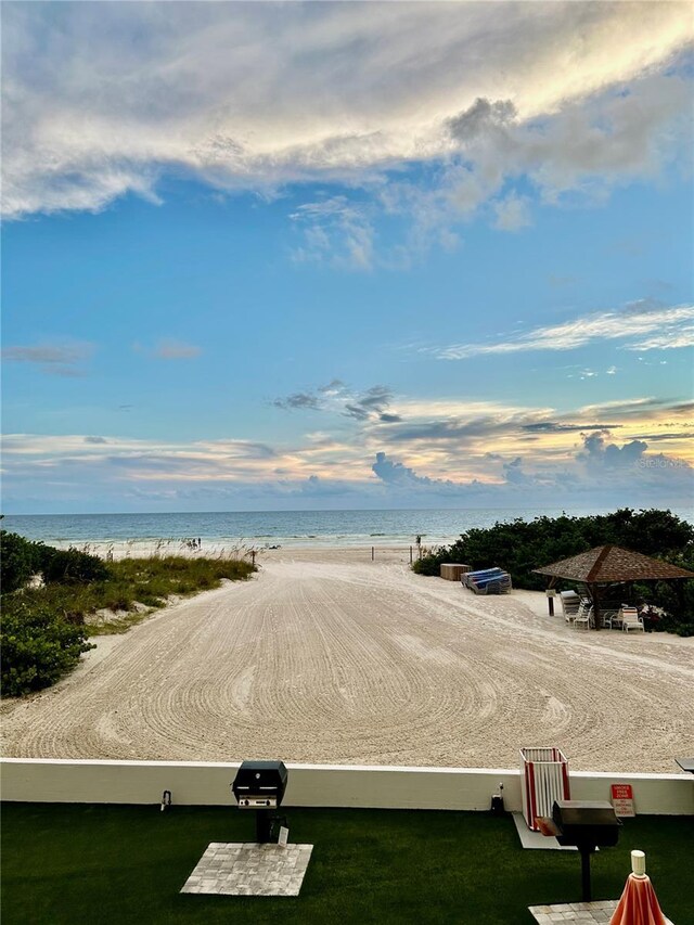 surrounding community with a water view and a beach view