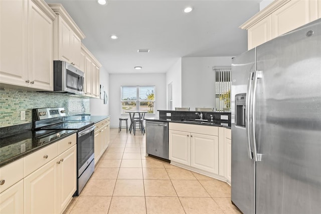 kitchen featuring light tile patterned flooring, sink, tasteful backsplash, dark stone counters, and stainless steel appliances