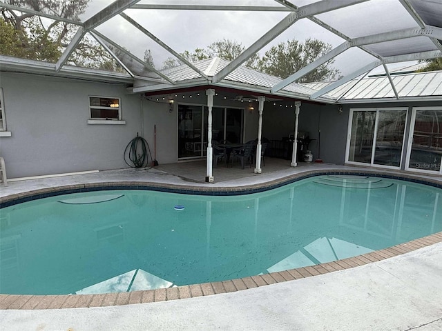 view of swimming pool with a patio area and glass enclosure