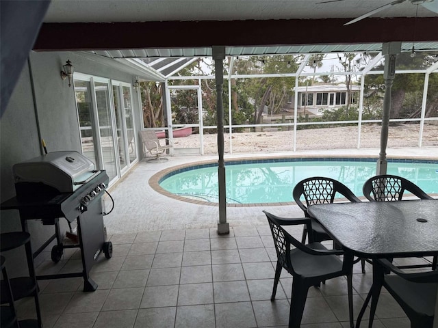 view of pool with a grill, glass enclosure, and a patio