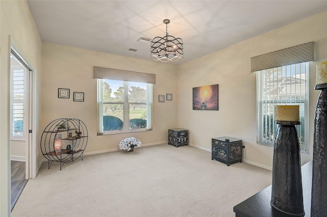 living area featuring light colored carpet and a chandelier