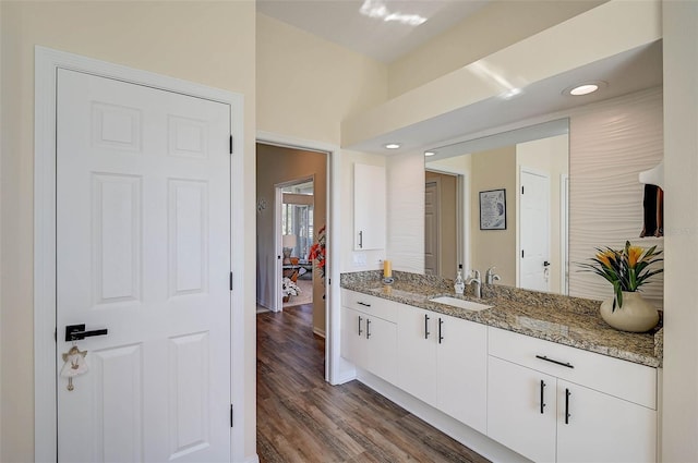 interior space featuring white cabinetry, dark hardwood / wood-style flooring, sink, and light stone counters