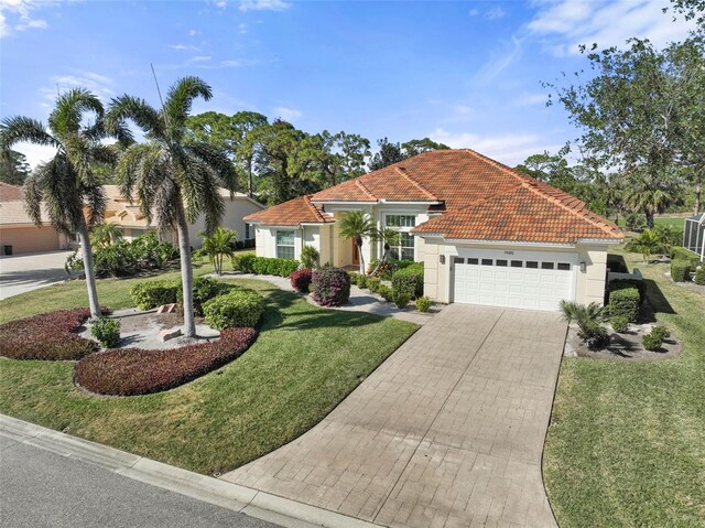 mediterranean / spanish home with a garage and a front lawn