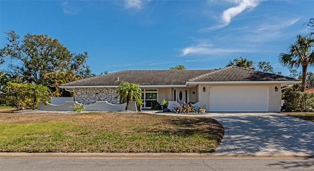 ranch-style home featuring a garage and a front lawn