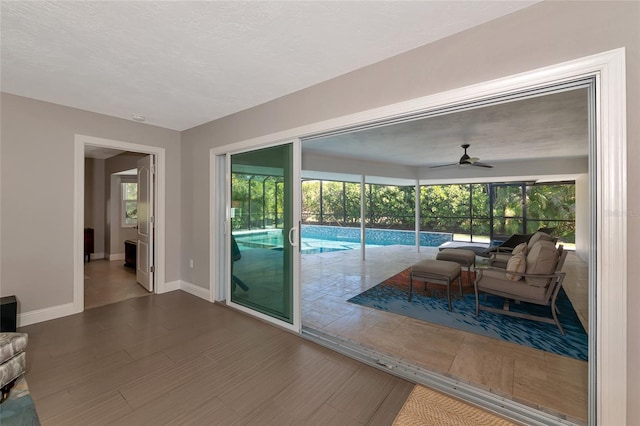 doorway to outside featuring a textured ceiling, hardwood / wood-style floors, and a wealth of natural light