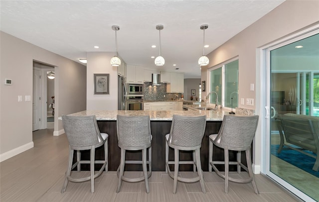 kitchen with white cabinetry, sink, stainless steel appliances, and decorative light fixtures