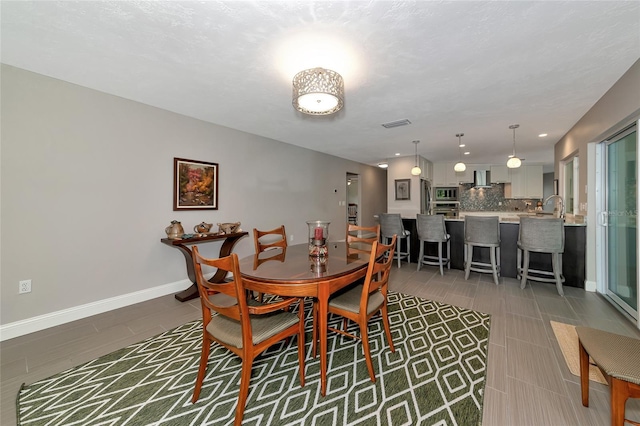 dining room with sink and dark tile patterned flooring