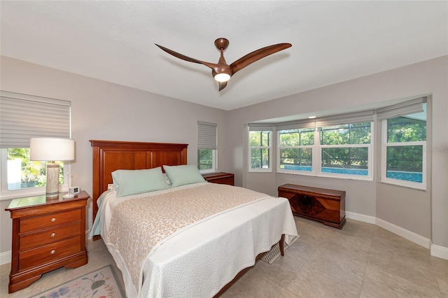 bedroom featuring multiple windows and ceiling fan