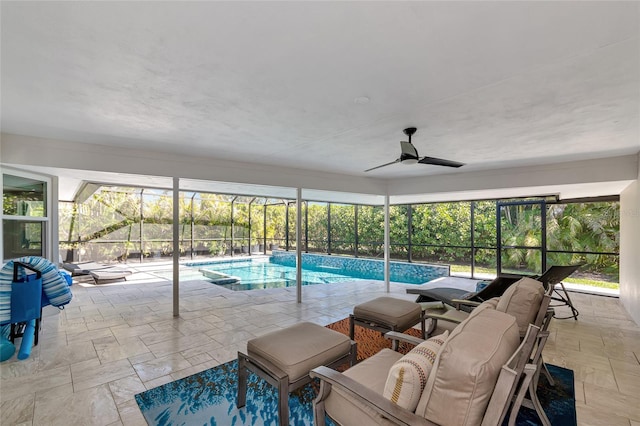 view of swimming pool with ceiling fan, glass enclosure, and a patio