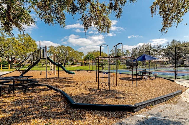 view of jungle gym featuring tennis court