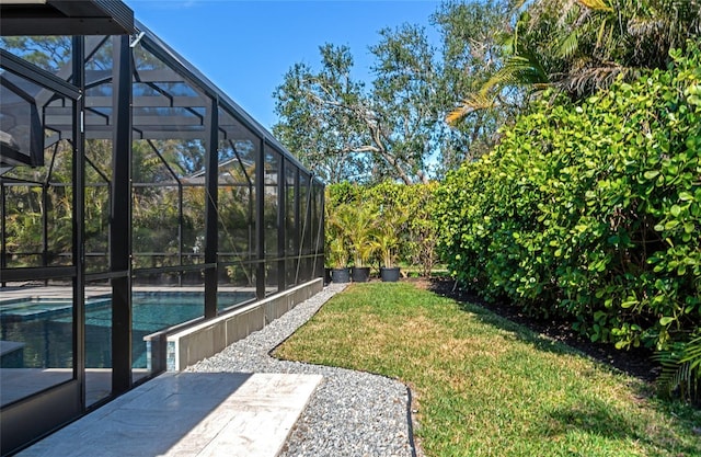 view of yard with glass enclosure and a patio