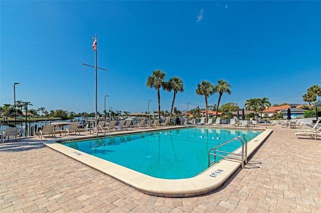 view of pool with a patio and a water view