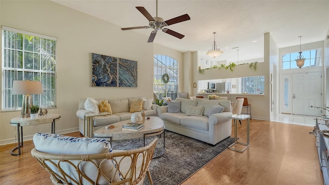 living room featuring light hardwood / wood-style flooring, a high ceiling, and plenty of natural light