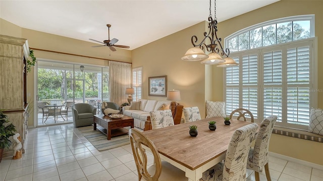 dining space with lofted ceiling, ceiling fan with notable chandelier, and light tile patterned floors