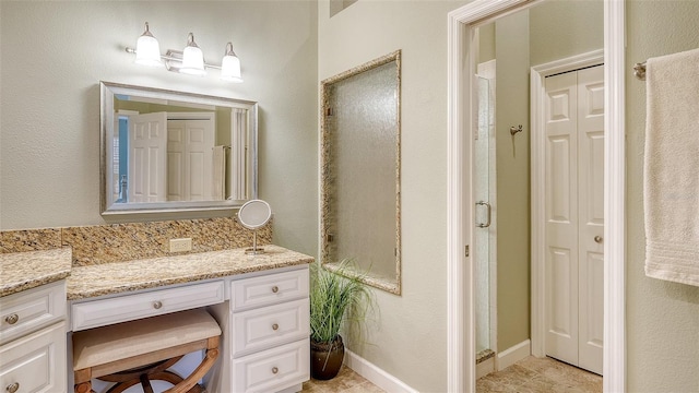 bathroom featuring a shower with door and vanity